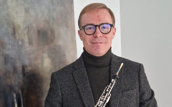 Lähikuvassa mies oboe kädessään.